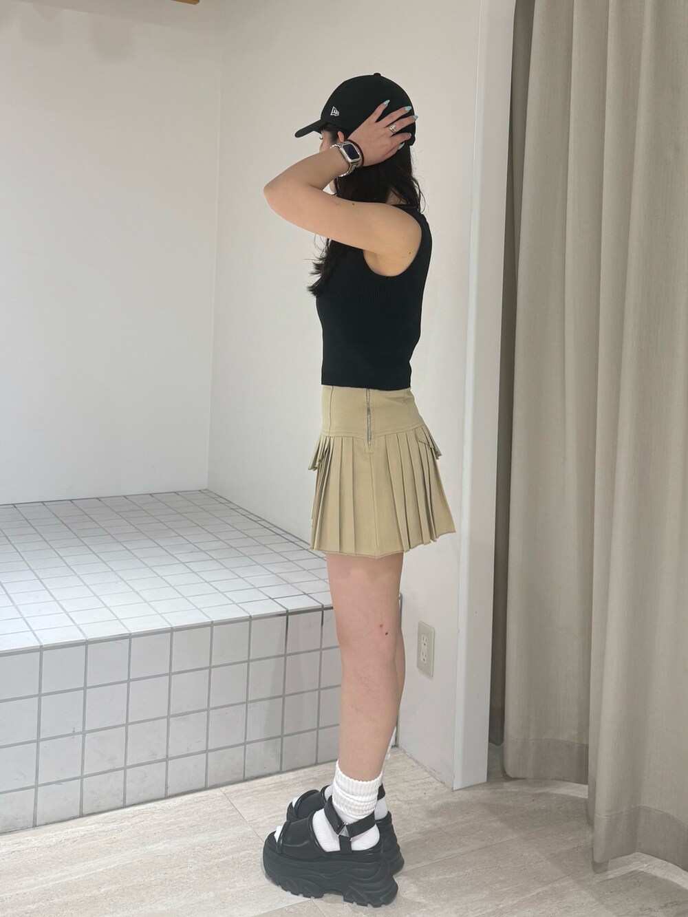 ブラック系のニット/セーター、ブラウン系のサンダル、グレー系のスカートを着用したレディースの夏コーディネートの2枚目の写真