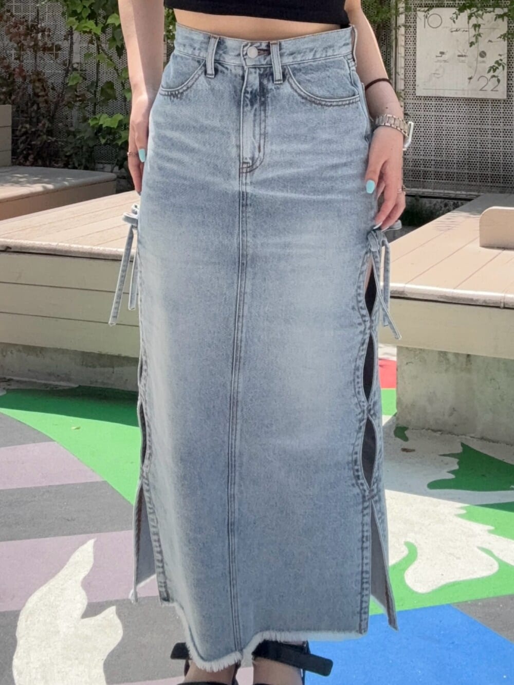 ブラウン系のサンダル、ブルー系のデニムスカート、ブラック系のTシャツ/カットソーを着用したレディースの春コーディネートの5枚目の写真