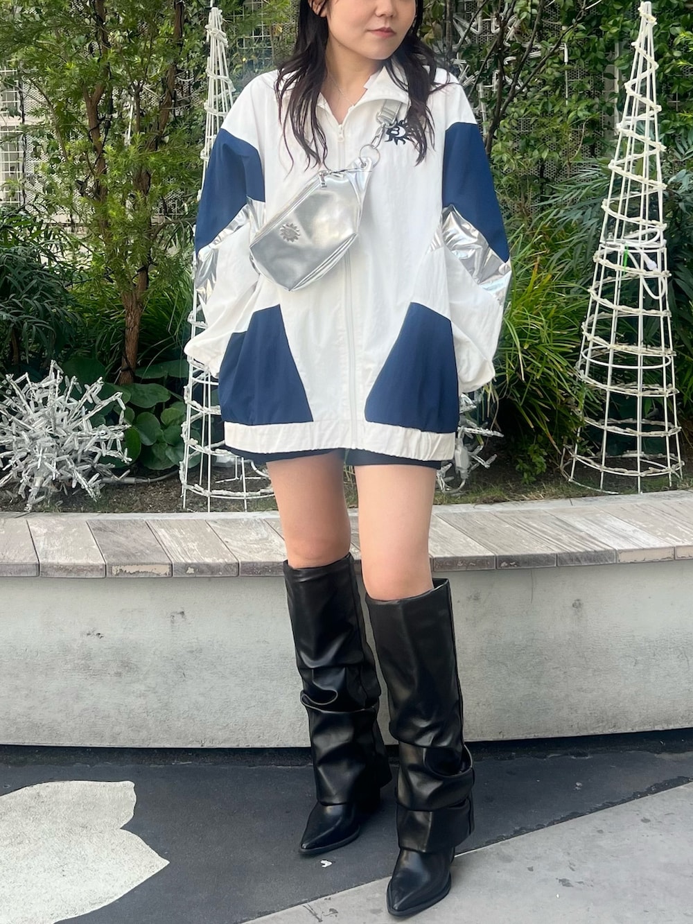 ホワイト系のナイロンジャケット、シルバー系のボディバッグ/ウエストポーチ、ブラック系のブーツを着用したレディースの冬コーディネートの4枚目の写真