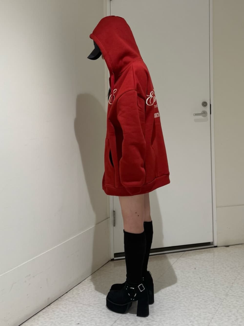 ブラック系のブーツ、レッド系のパーカーを着用したレディースの秋コーディネートの2枚目の写真