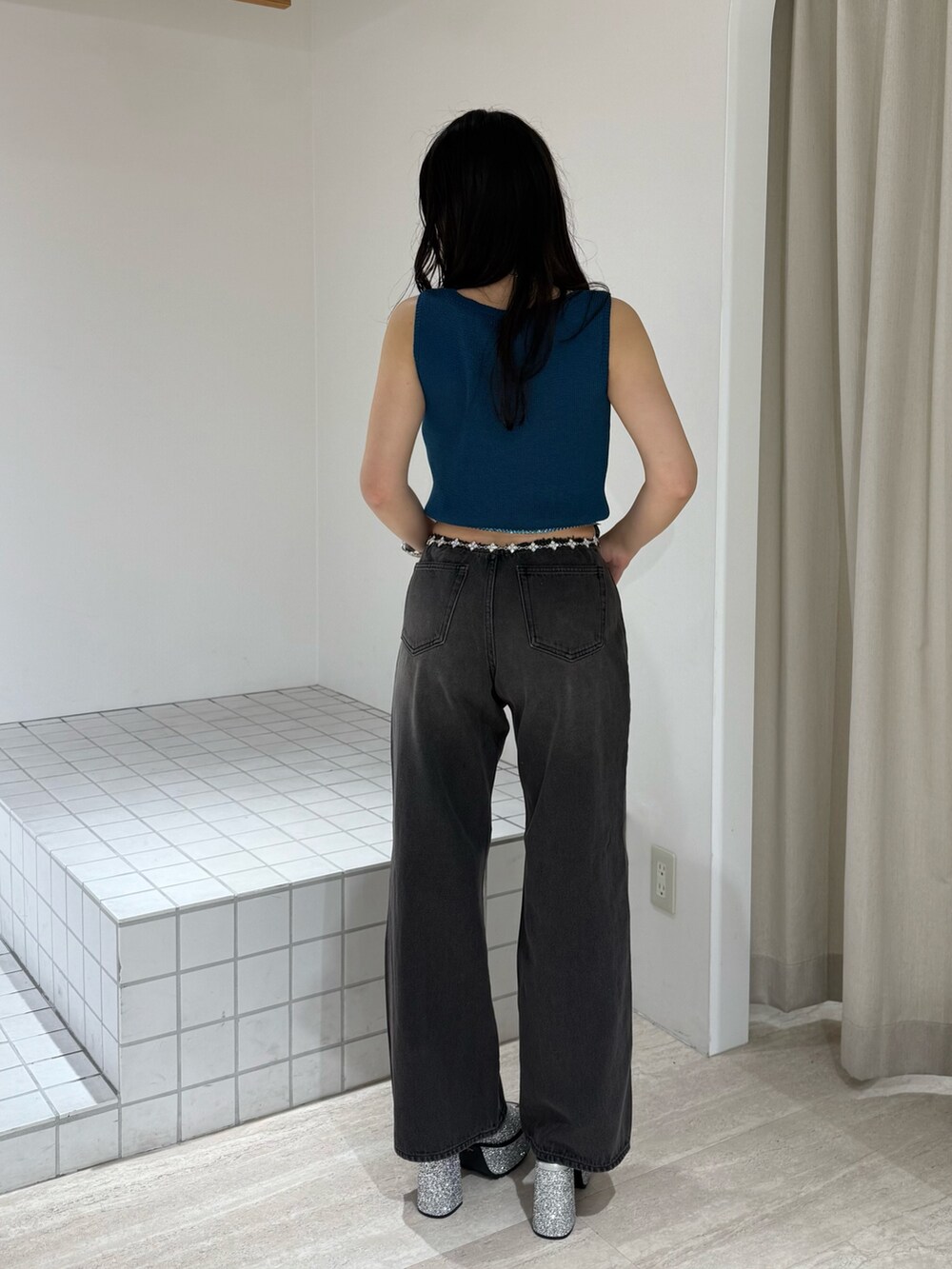 ブルー系のニット/セーター、シルバー系のサンダル、ブラック系のデニムパンツを着用したレディースの夏コーディネートの3枚目の写真