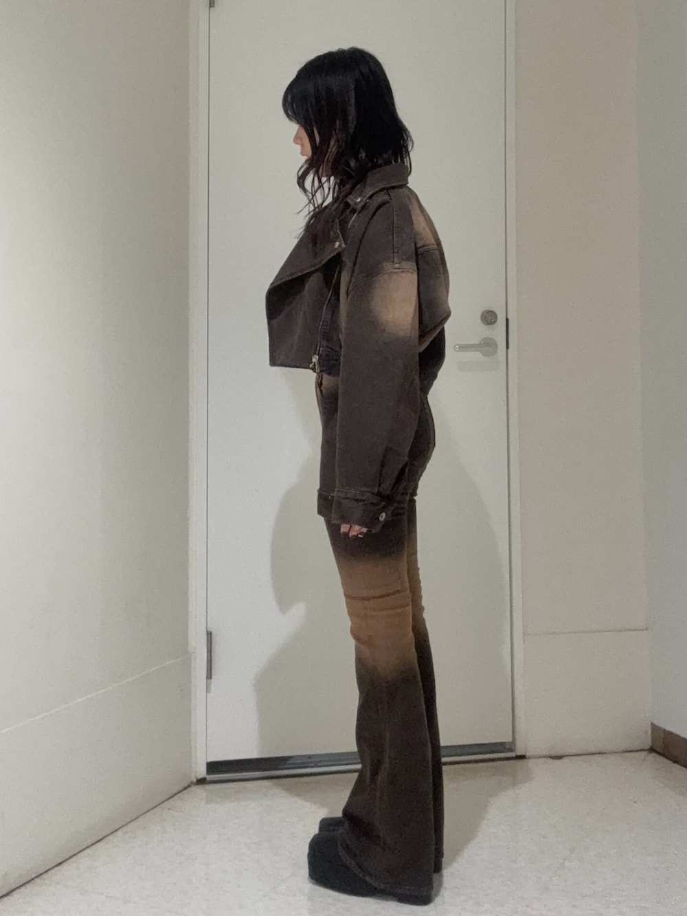 ブラック系のブーツ、ブラウン系のタンクトップ、ブラウン系のデニムジャケットを着用したレディースの秋コーディネートの2枚目の写真