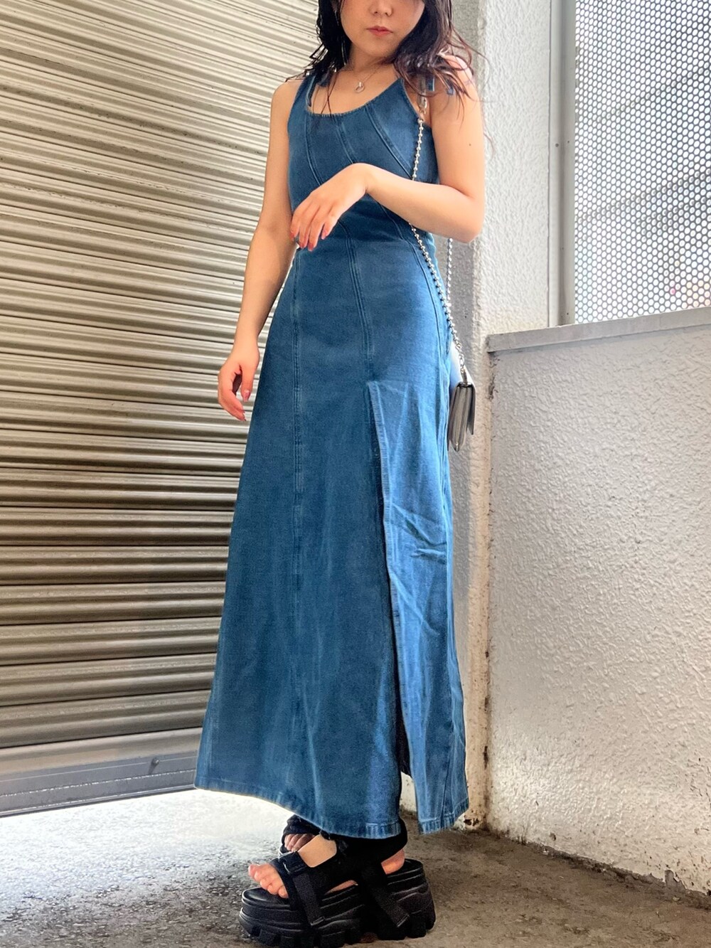 ブルー系のワンピース、ブラック系のサンダル、シルバー系のショルダーバッグを着用したレディースの春コーディネートの2枚目の写真