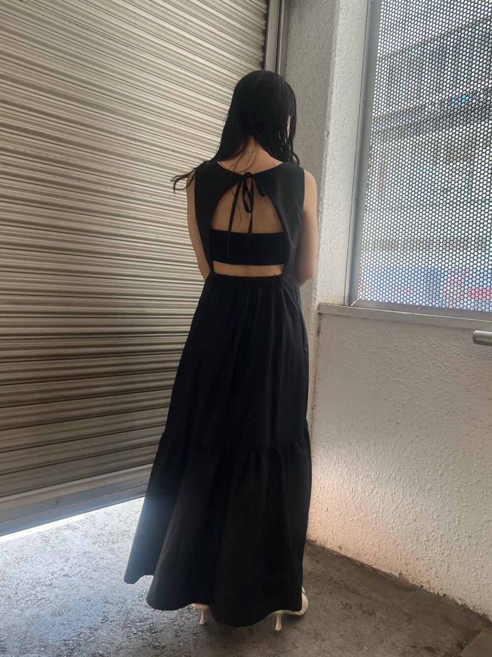 ブラック系のワンピース、ホワイト系のサンダルを着用したレディースの夏コーディネートの4枚目の写真