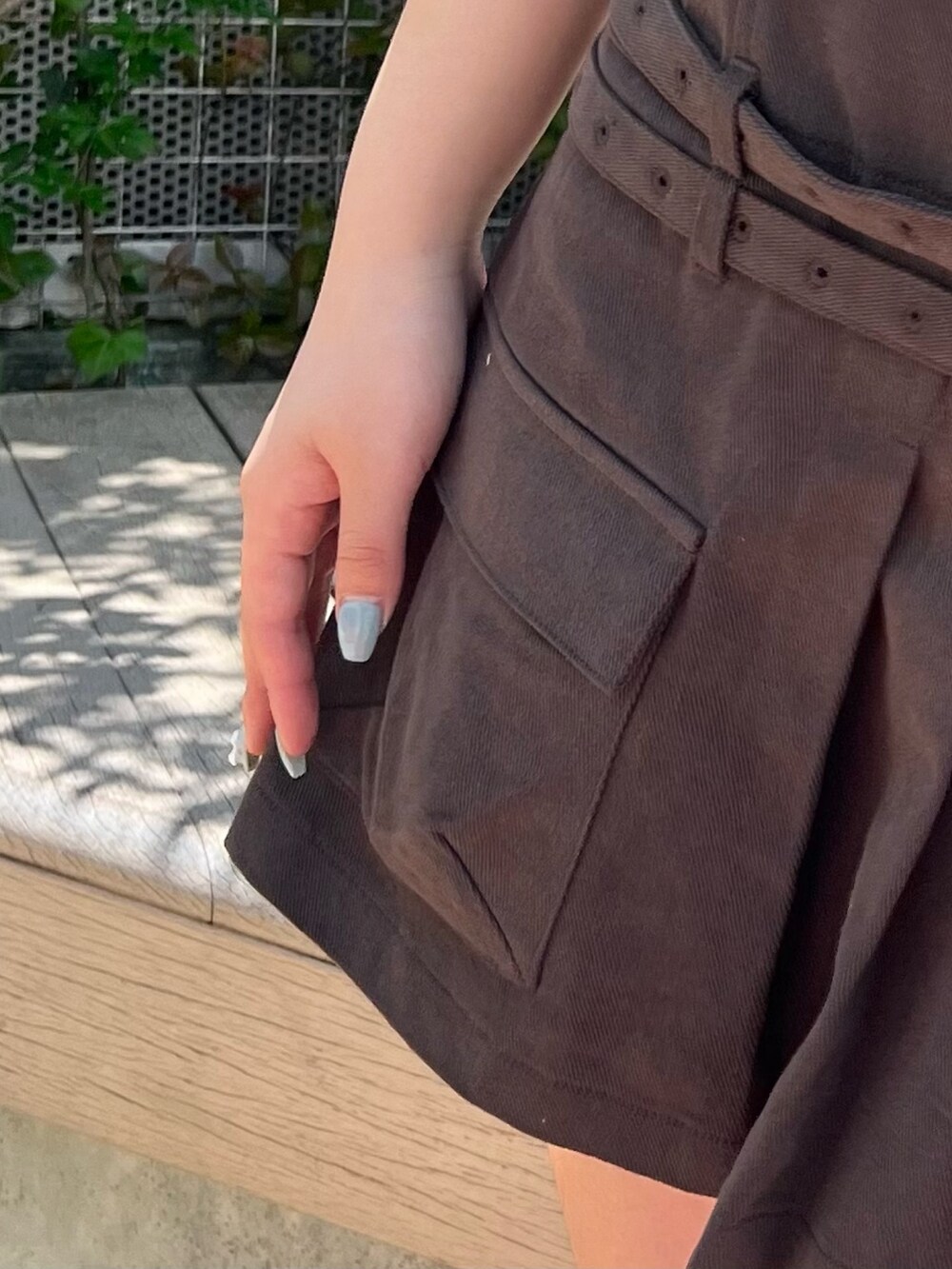 グレー系のジャンパースカート、ブラック系のサンダルを着用したレディースの春コーディネートの6枚目の写真