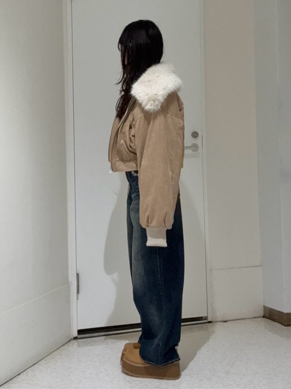 ブルー系のデニムパンツ、ベージュ系のスリッポン、ベージュ系のブルゾンを着用したレディースの秋コーディネートの2枚目の写真