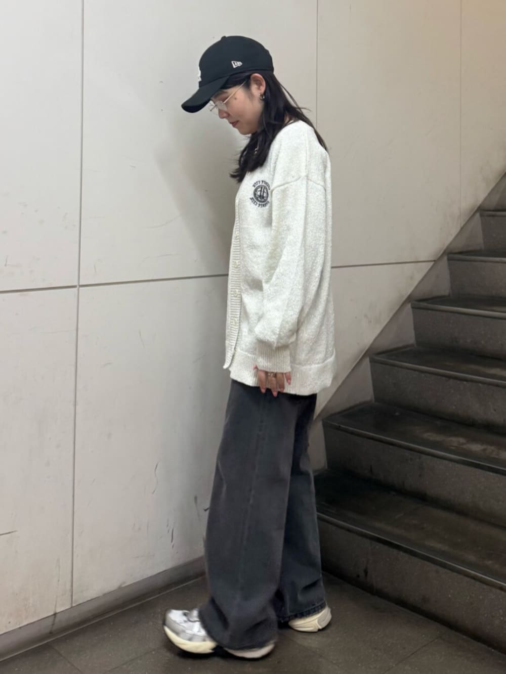 グレー系のニット/セーター、ホワイト系のカーディガン/ボレロ、ブラック系のデニムパンツを着用したレディースの春コーディネートの3枚目の写真