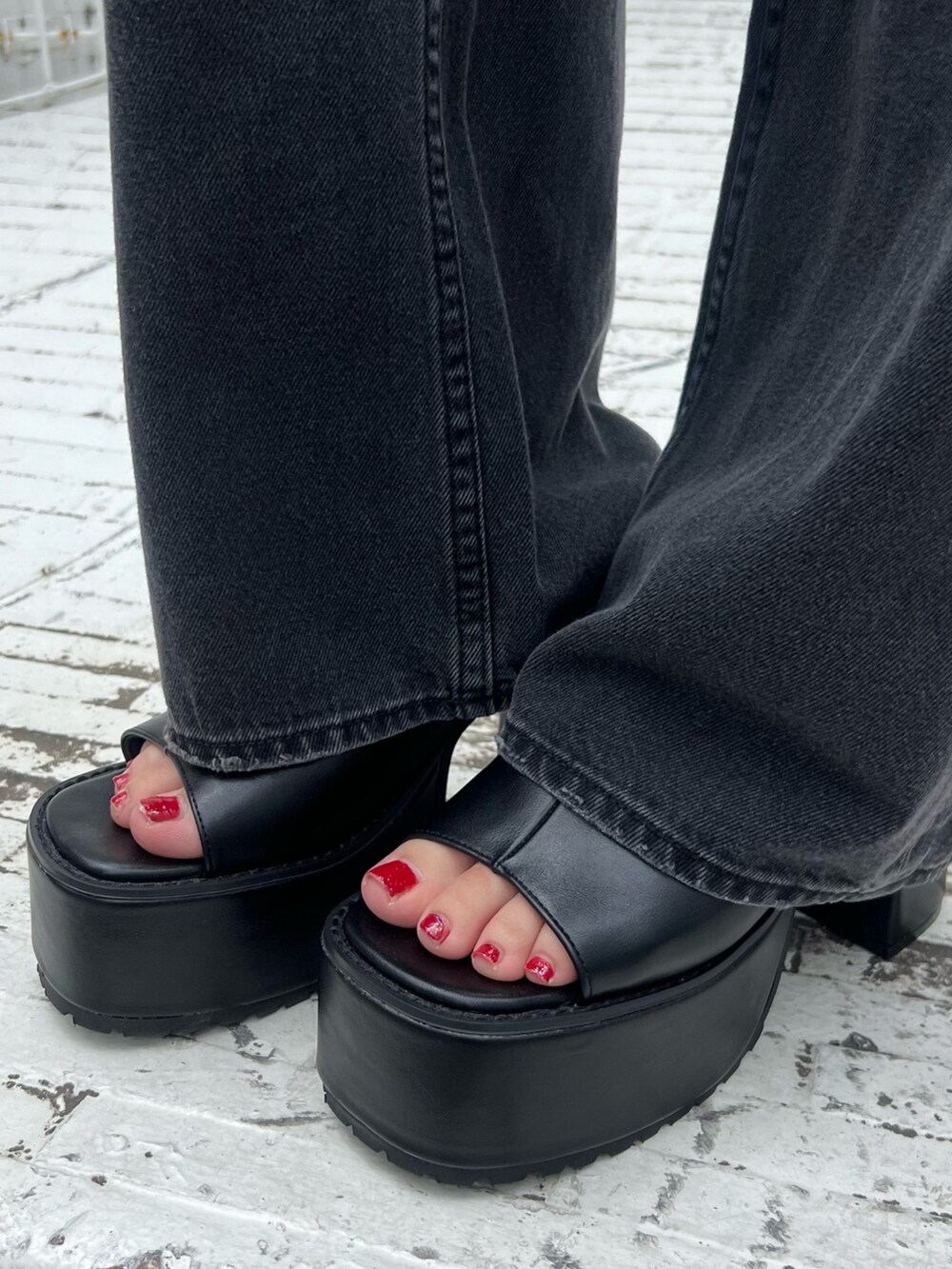 ブラック系のデニムパンツ、ブラック系のサンダル、ブラック系のニット/セーターを着用したレディースの夏コーディネートの7枚目の写真