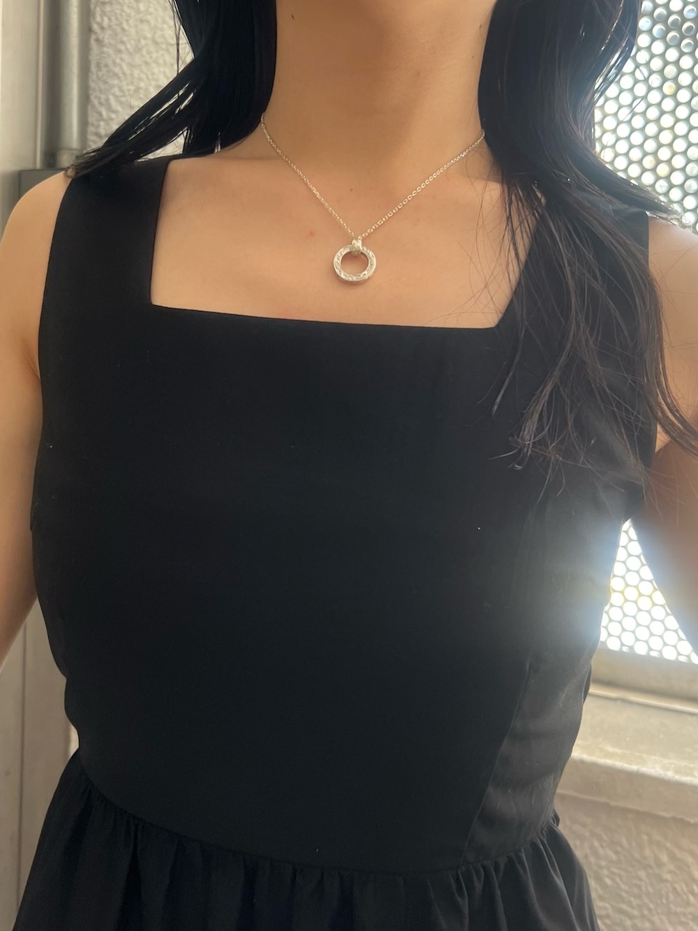 ブラック系のワンピース、ホワイト系のサンダルを着用したレディースの夏コーディネートの6枚目の写真