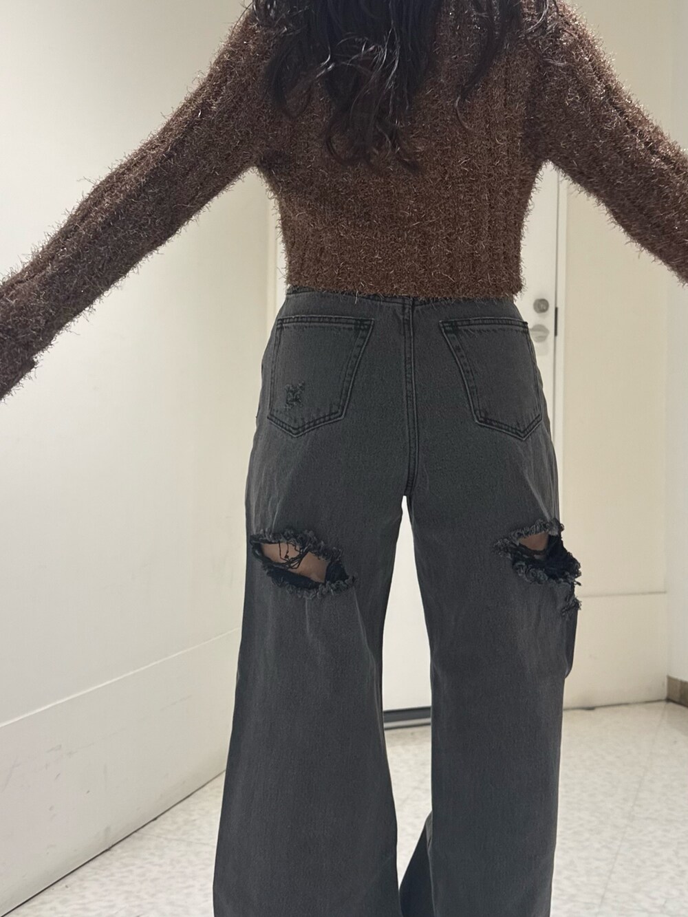 ブラック系のデニムパンツ、ブラウン系のカーディガン/ボレロを着用したレディースの秋コーディネートの4枚目の写真