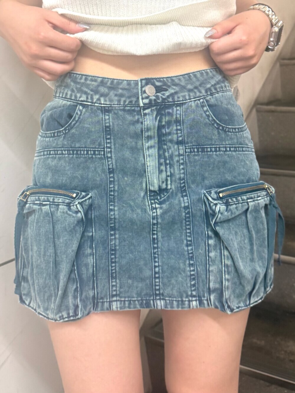 ブラック系のブーツ、ブルー系のスカート、ホワイト系のニット/セーターを着用したレディースの夏コーディネートの5枚目の写真