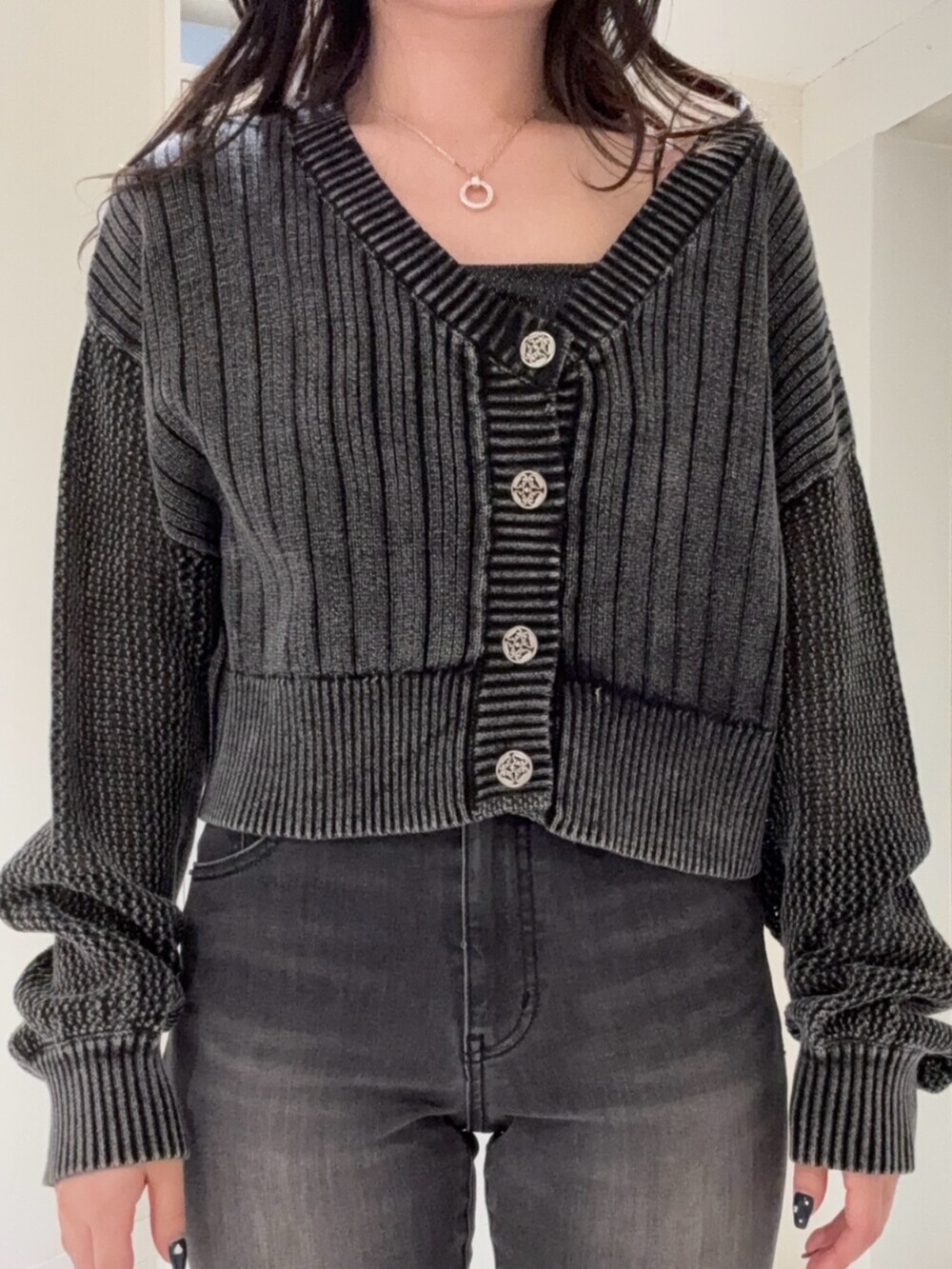 ブラック系のデニムパンツ、ブラック系のブーツ、ホワイト系のカーディガン/ボレロを着用したレディースの春コーディネートの4枚目の写真