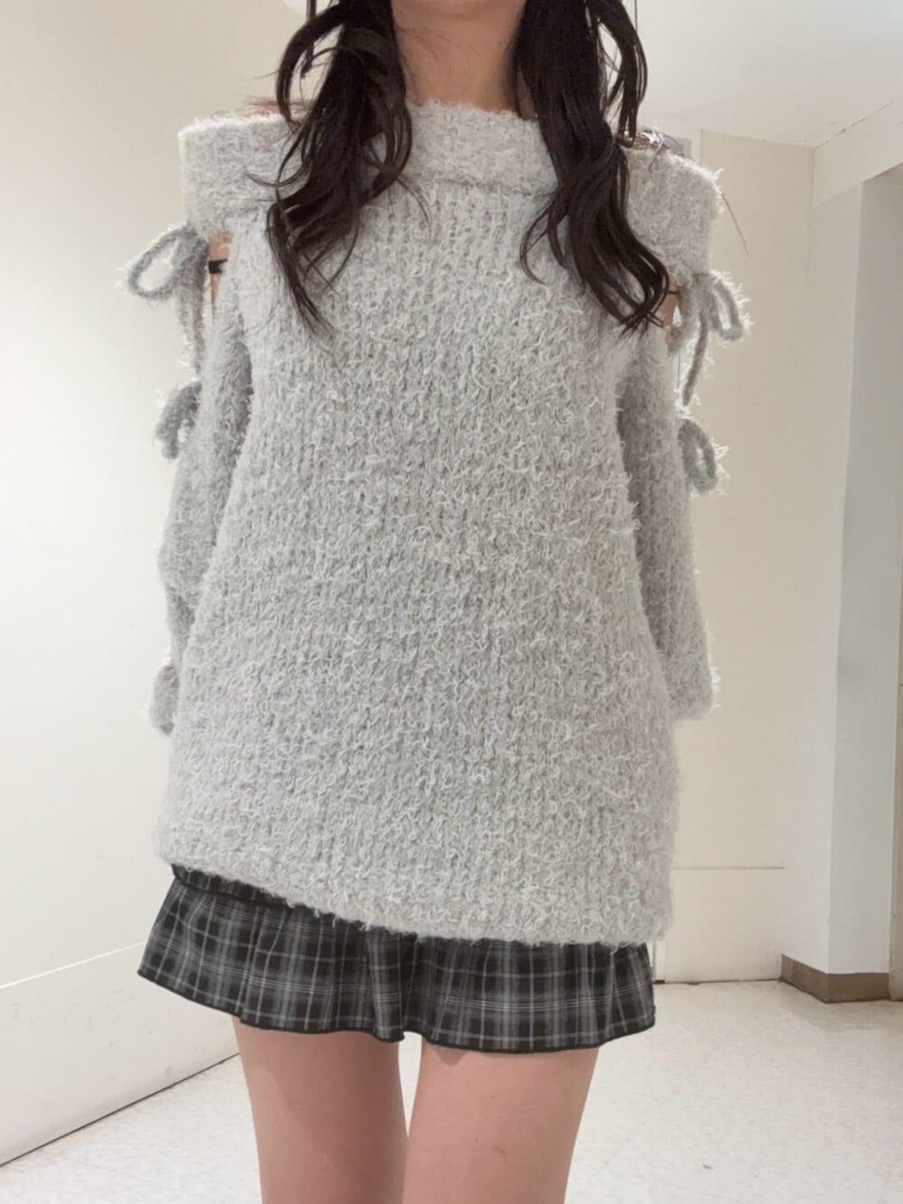 ブラック系のブーツ、ブラック系のスカート、グレー系のワンピースを着用したレディースの冬コーディネートの4枚目の写真