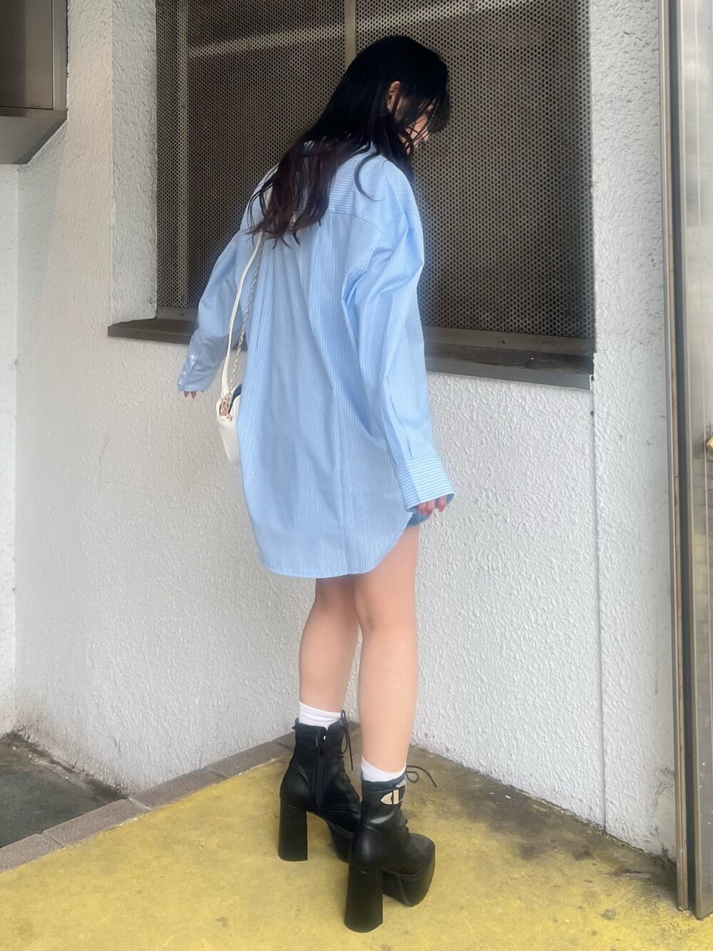 ブルー系のデニムスカート、ブルー系のシャツ/ブラウス、ホワイト系のショルダーバッグを着用したレディースの春コーディネートの3枚目の写真