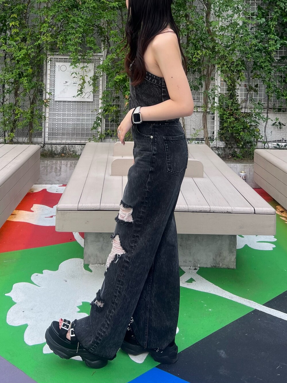 ブラック系のデニムパンツ、ブラック系のサンダル、ブラック系のキャミソールを着用したレディースの夏コーディネートの3枚目の写真