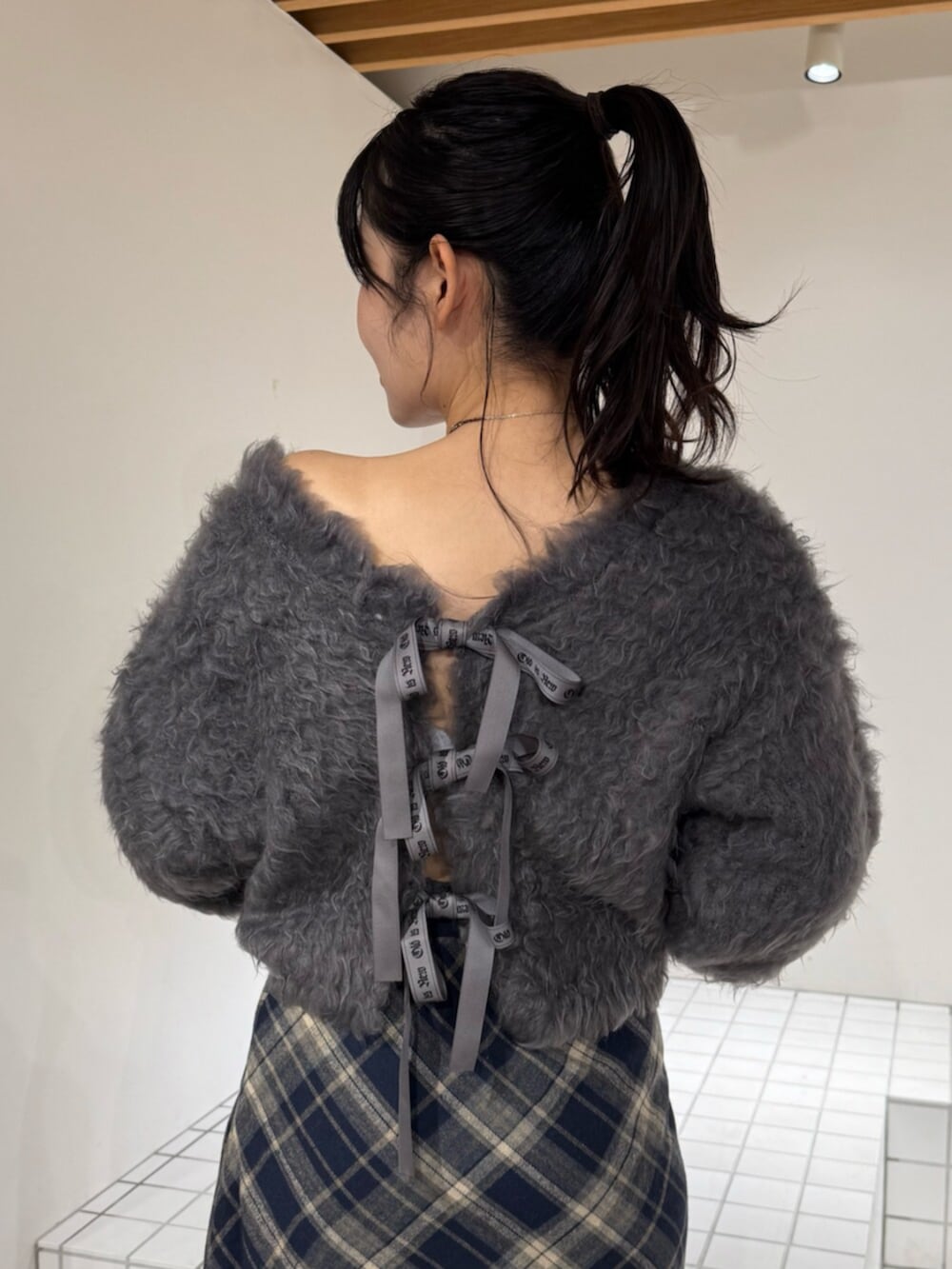 ブルー系のスカート、ブラック系のブーツ、グレー系のニット/セーターを着用したレディースの秋コーディネートの4枚目の写真