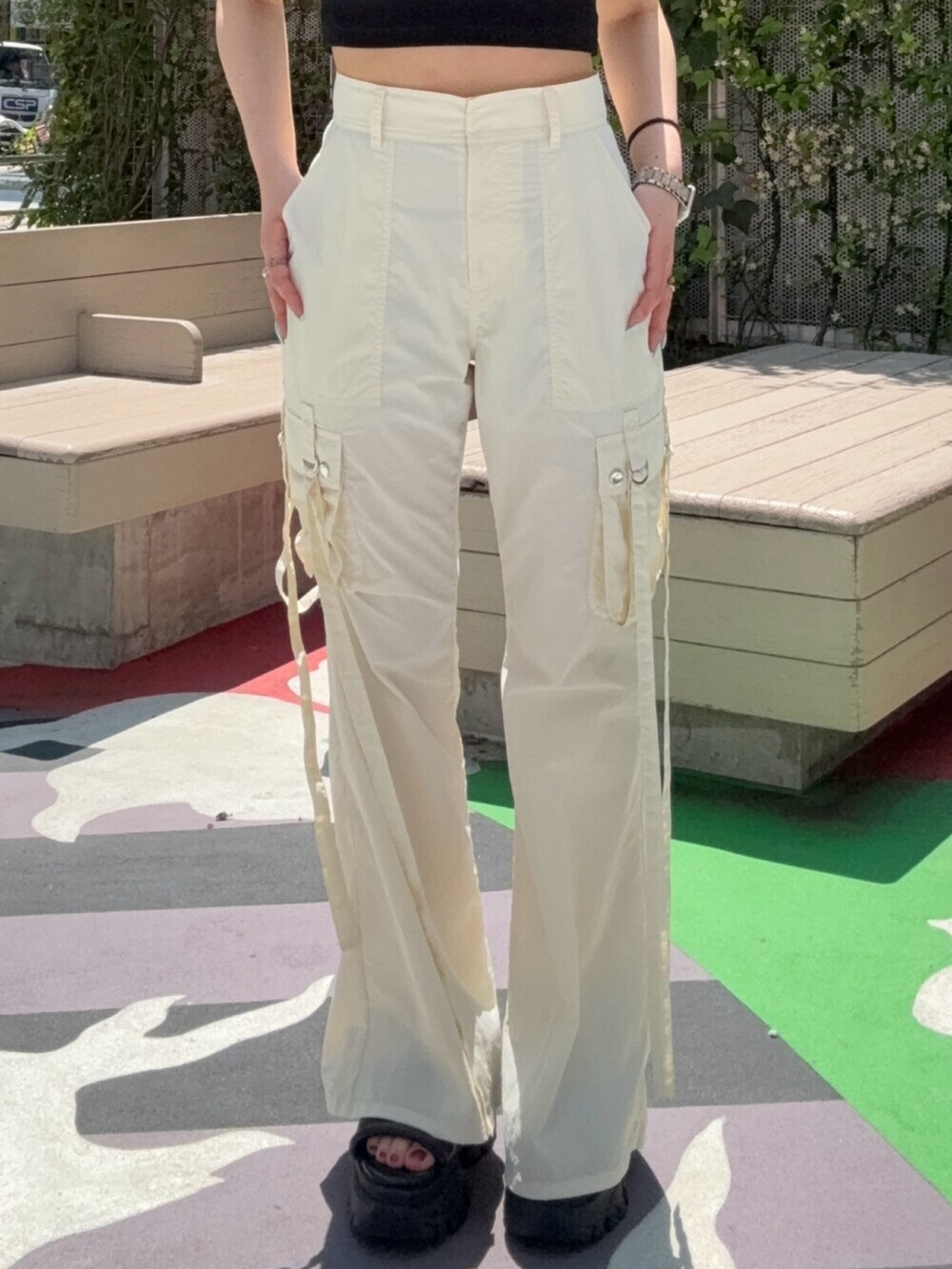 ブラウン系のサンダル、ブラック系のTシャツ/カットソー、ホワイト系のカーゴパンツを着用したレディースの春コーディネートの5枚目の写真