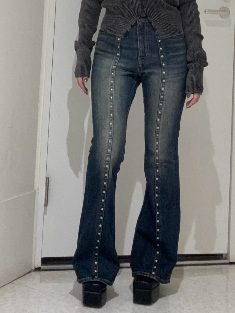 ブルー系のデニムパンツ、ブラック系のブーツ、ブルー系のキャミソールを着用したレディースの夏コーディネートの5枚目の写真