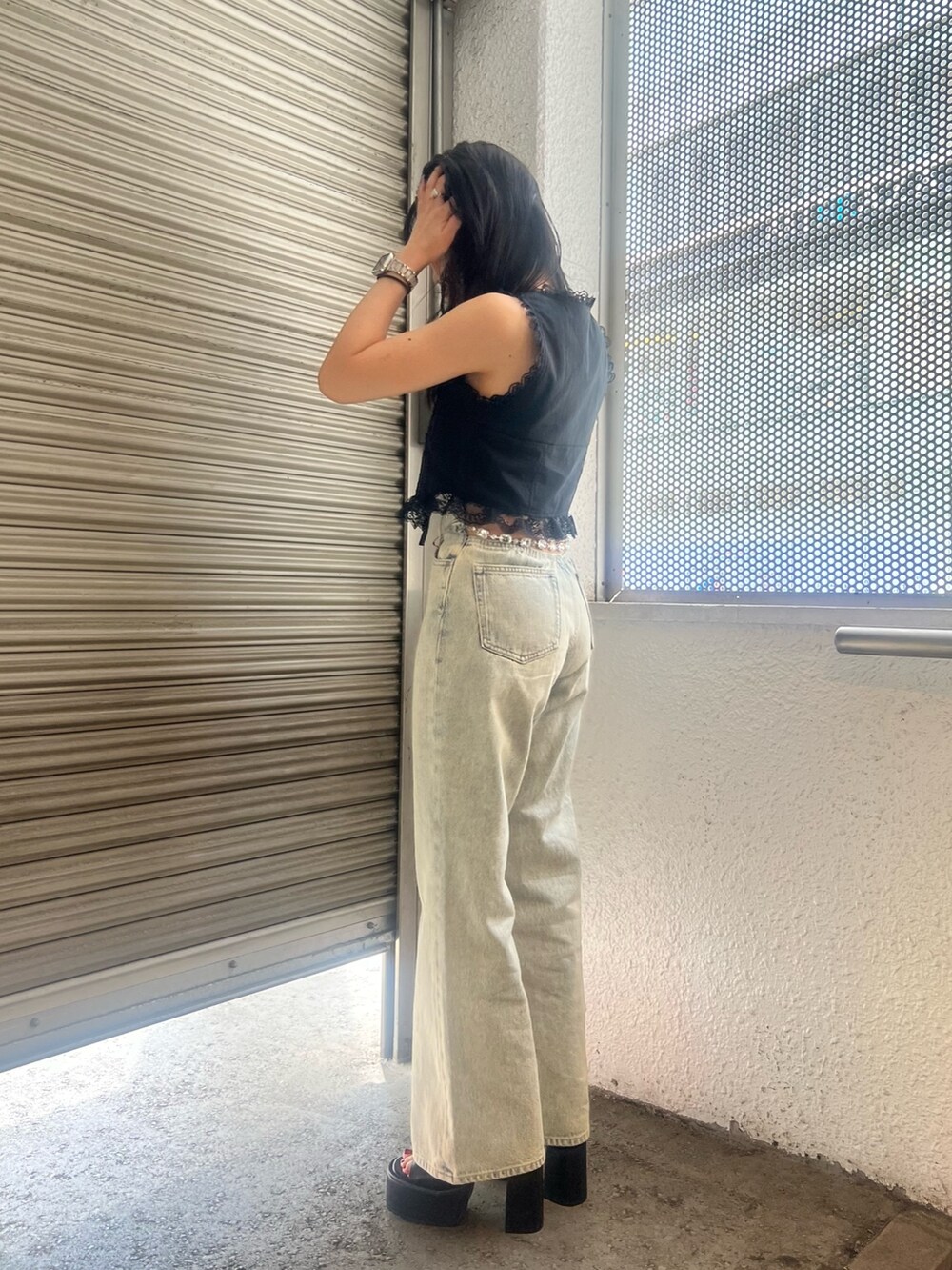 ブルー系のデニムパンツ、ブラック系のサンダルを着用したレディースの夏コーディネートの3枚目の写真