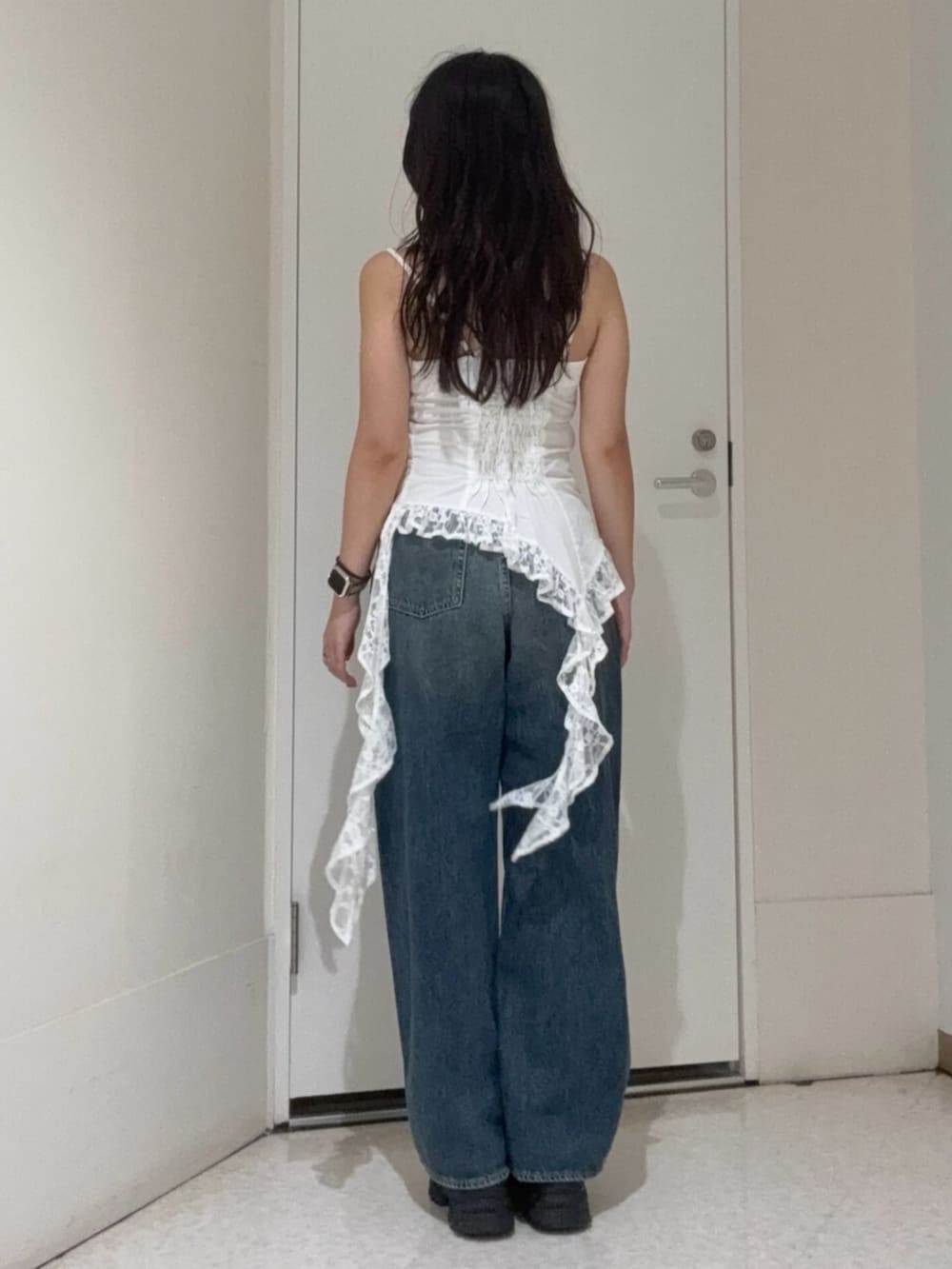 ブラウン系のサンダル、ホワイト系のキャミソール、ブルー系のデニムパンツを着用したレディースの夏コーディネートの3枚目の写真