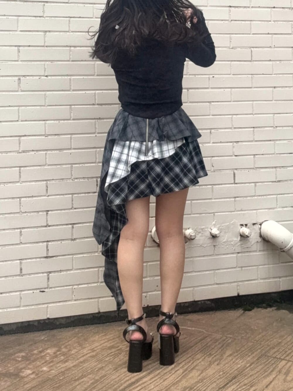 レッド系のTシャツ/カットソー、ブラック系のスカート、ブラック系のサンダルを着用したレディースの春コーディネートの3枚目の写真