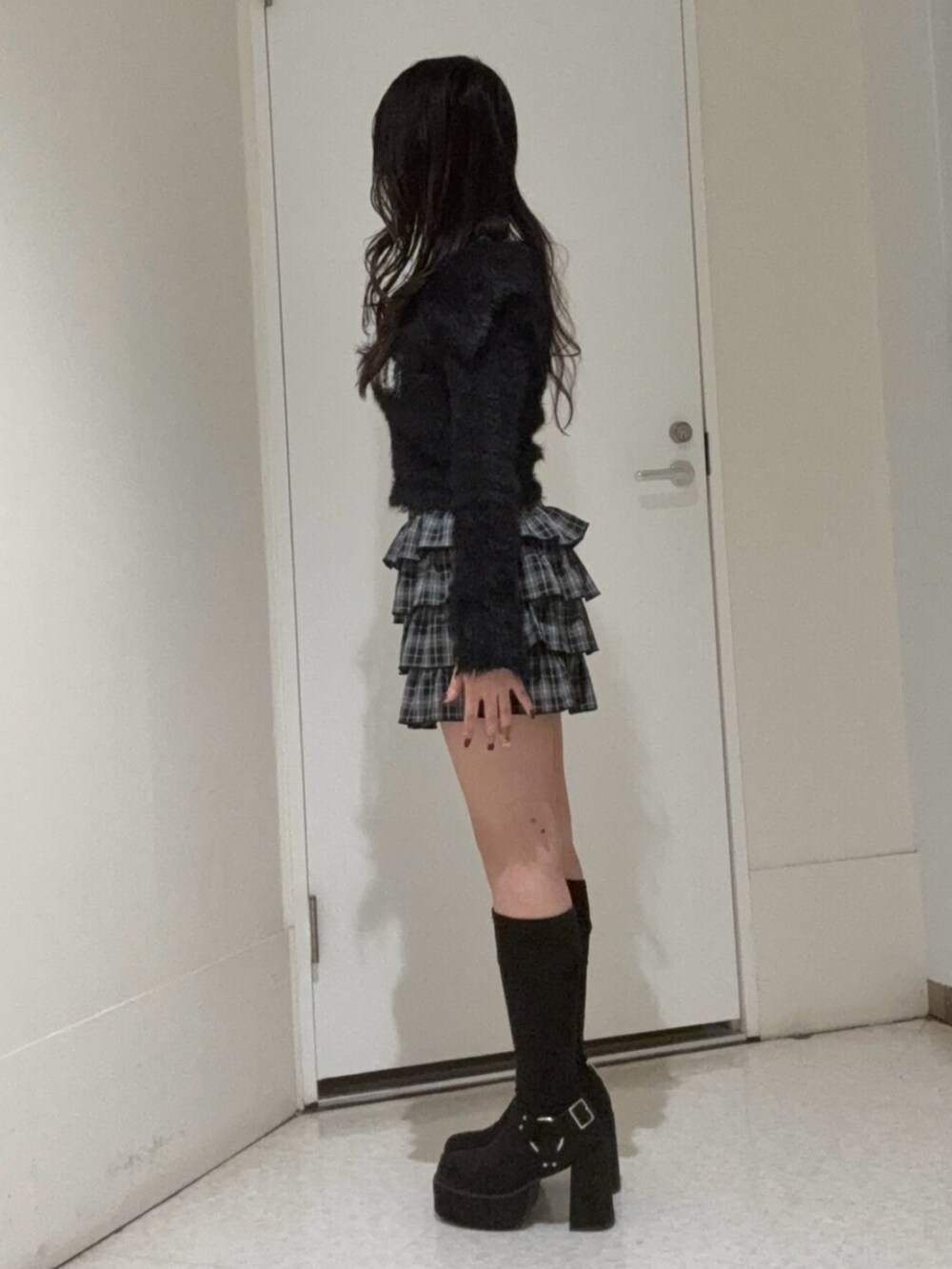 ブラック系のブーツ、ブラック系のスカート、ブラック系のニット/セーターを着用したレディースの冬コーディネートの2枚目の写真