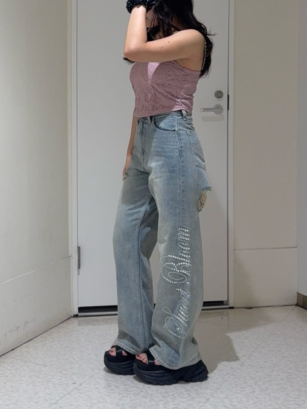 ブラック系のサンダル、ブルー系のデニムパンツ、ピンク系のキャミソールを着用したレディースの夏コーディネートの2枚目の写真