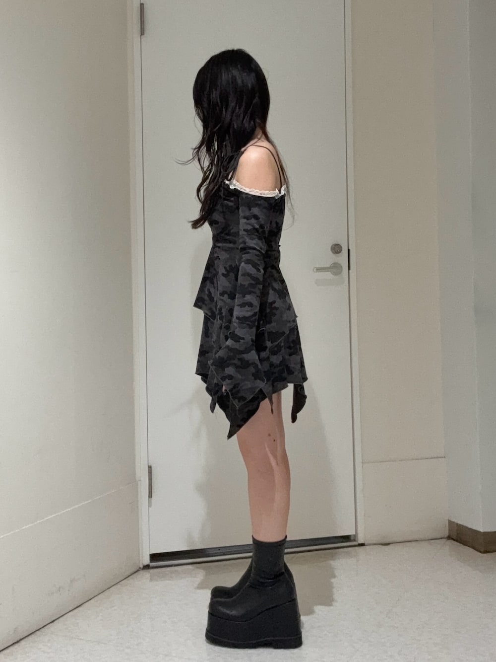 ブラック系のワンピース、ブラック系のブーツを着用したレディースの春コーディネートの2枚目の写真