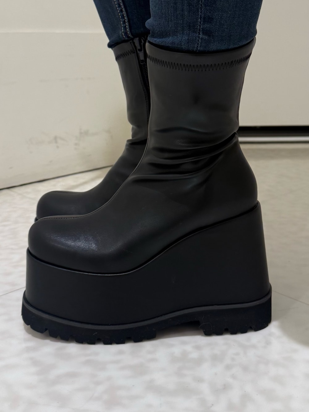 ブラック系のスウェット、ブラック系のブーツ、ブルー系のデニムパンツを着用したレディースの冬コーディネートの5枚目の写真