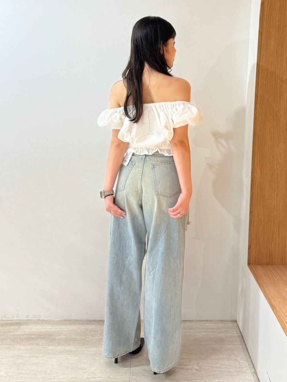 ブルー系のデニムパンツ、ホワイト系のシャツ/ブラウス、ブラック系のパンプスを着用したレディースの夏コーディネートの3枚目の写真