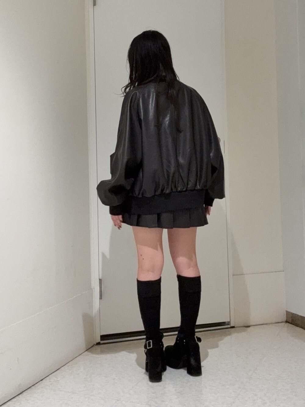 ブラック系のスカート、ブラック系のブーツ、ブラック系のブルゾンを着用したレディースの秋コーディネートの3枚目の写真