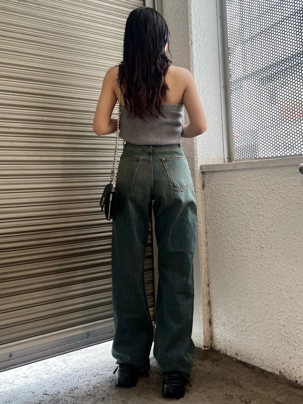 ブルー系のデニムパンツ、グレー系のキャミソール、ブラック系のショルダーバッグを着用したレディースの春コーディネートの4枚目の写真