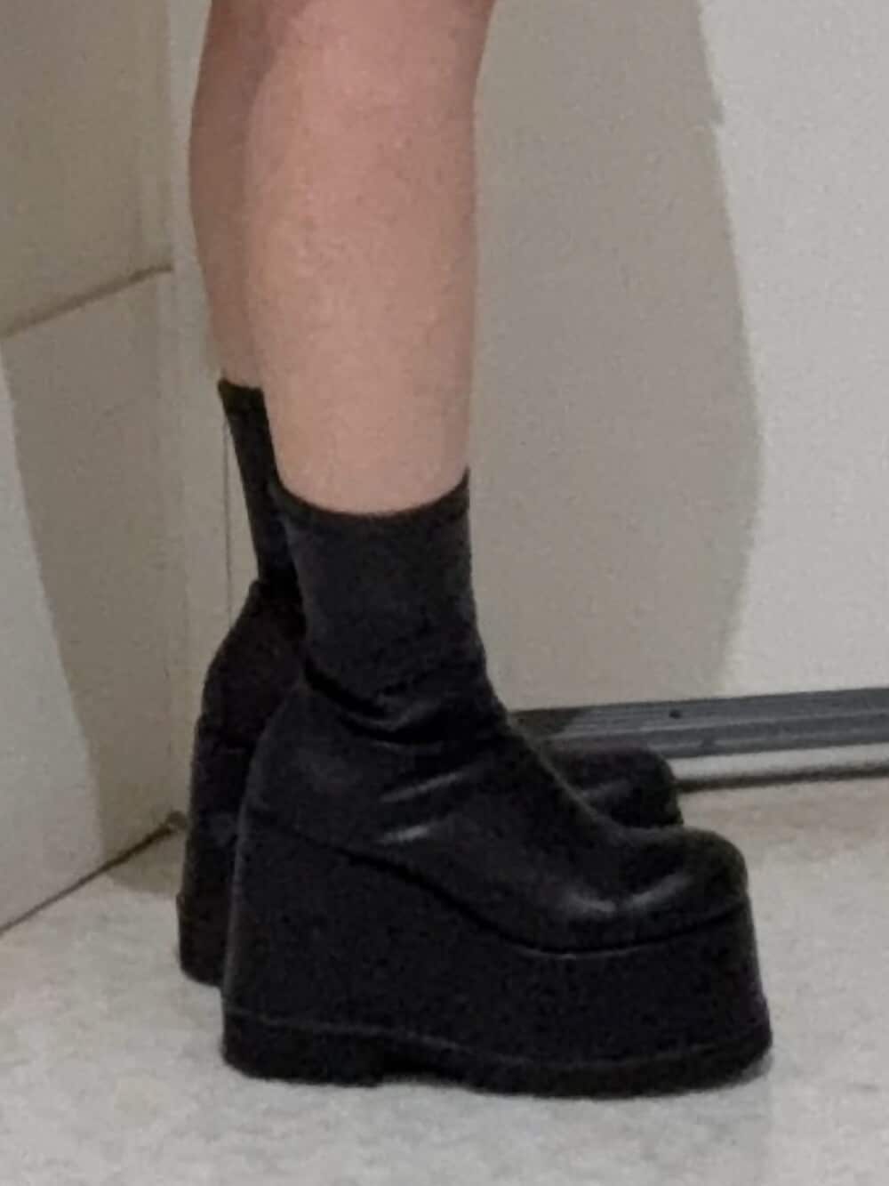 ピンク系のパーカー、ブラック系のライダースジャケット、ブラック系のブーツを着用したレディースの春コーディネートの5枚目の写真