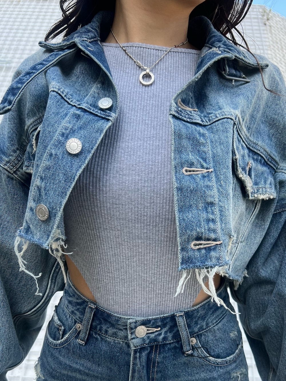 グレー系のTシャツ/カットソー、ブルー系のデニムジャケット、ブルー系のデニムパンツを着用したレディースの冬コーディネートの7枚目の写真