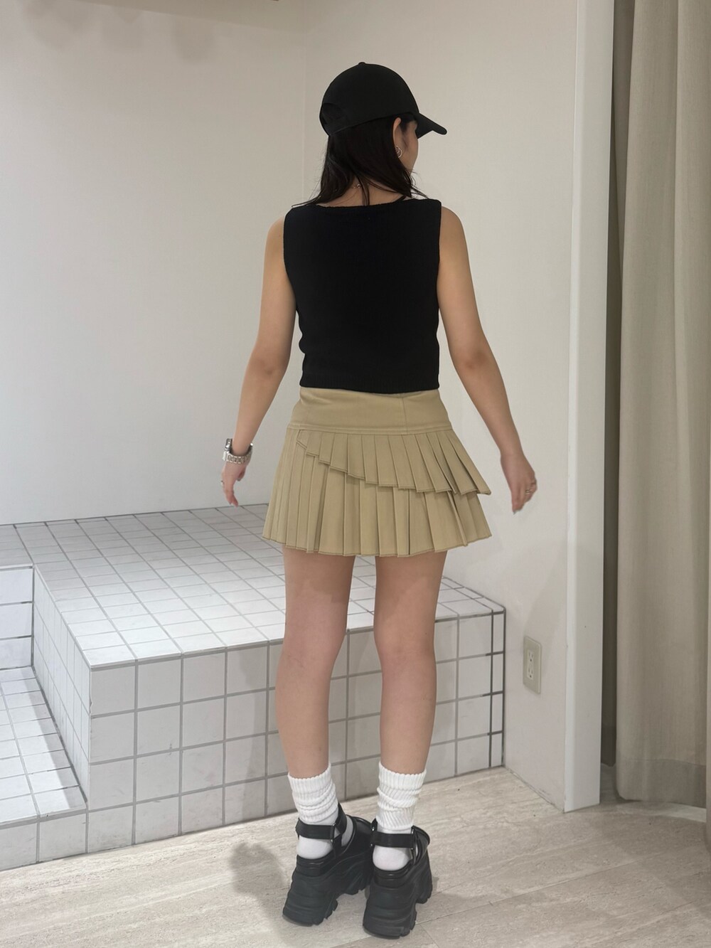 ブラック系のニット/セーター、ブラウン系のサンダル、グレー系のスカートを着用したレディースの夏コーディネートの3枚目の写真