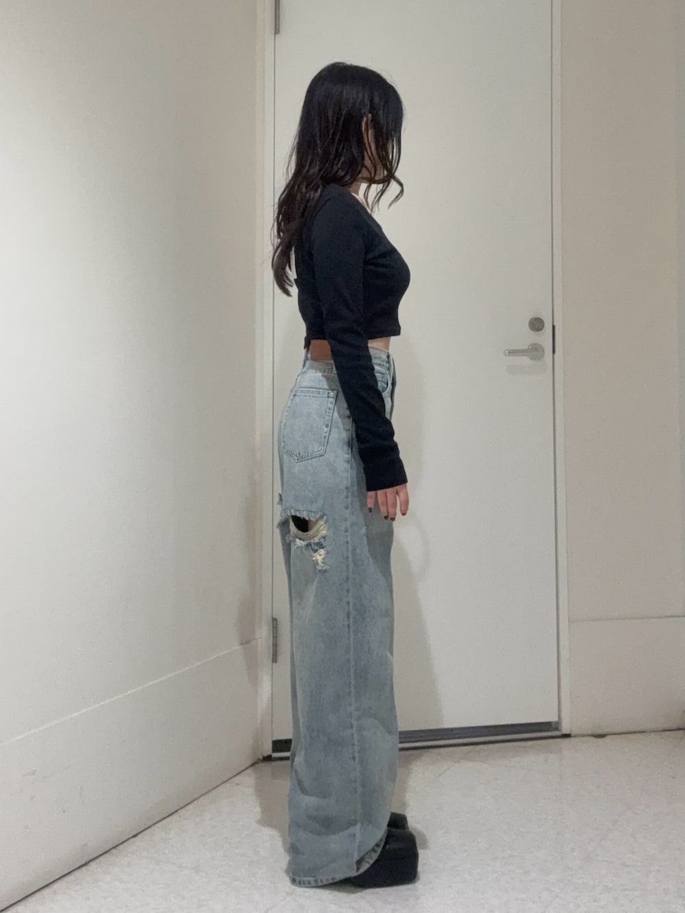 ブラック系のブーツ、ブルー系のデニムパンツ、ブラック系のTシャツ/カットソーを着用したレディースの秋コーディネートの2枚目の写真