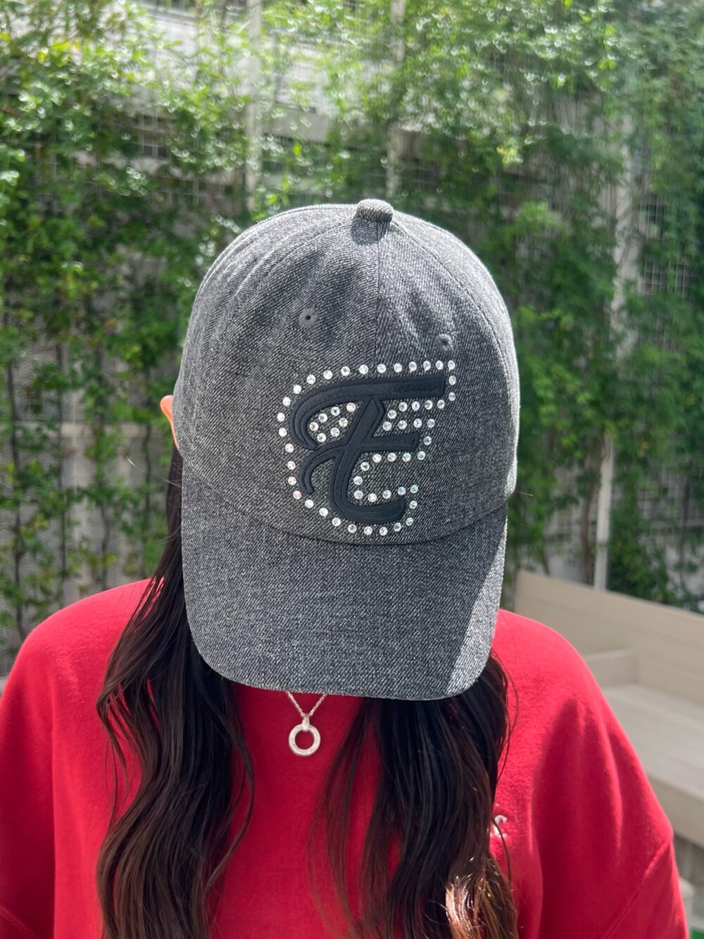 レッド系のスウェット、ブラック系のショルダーバッグ、ブラック系のブーツを着用したレディースの夏コーディネートの5枚目の写真