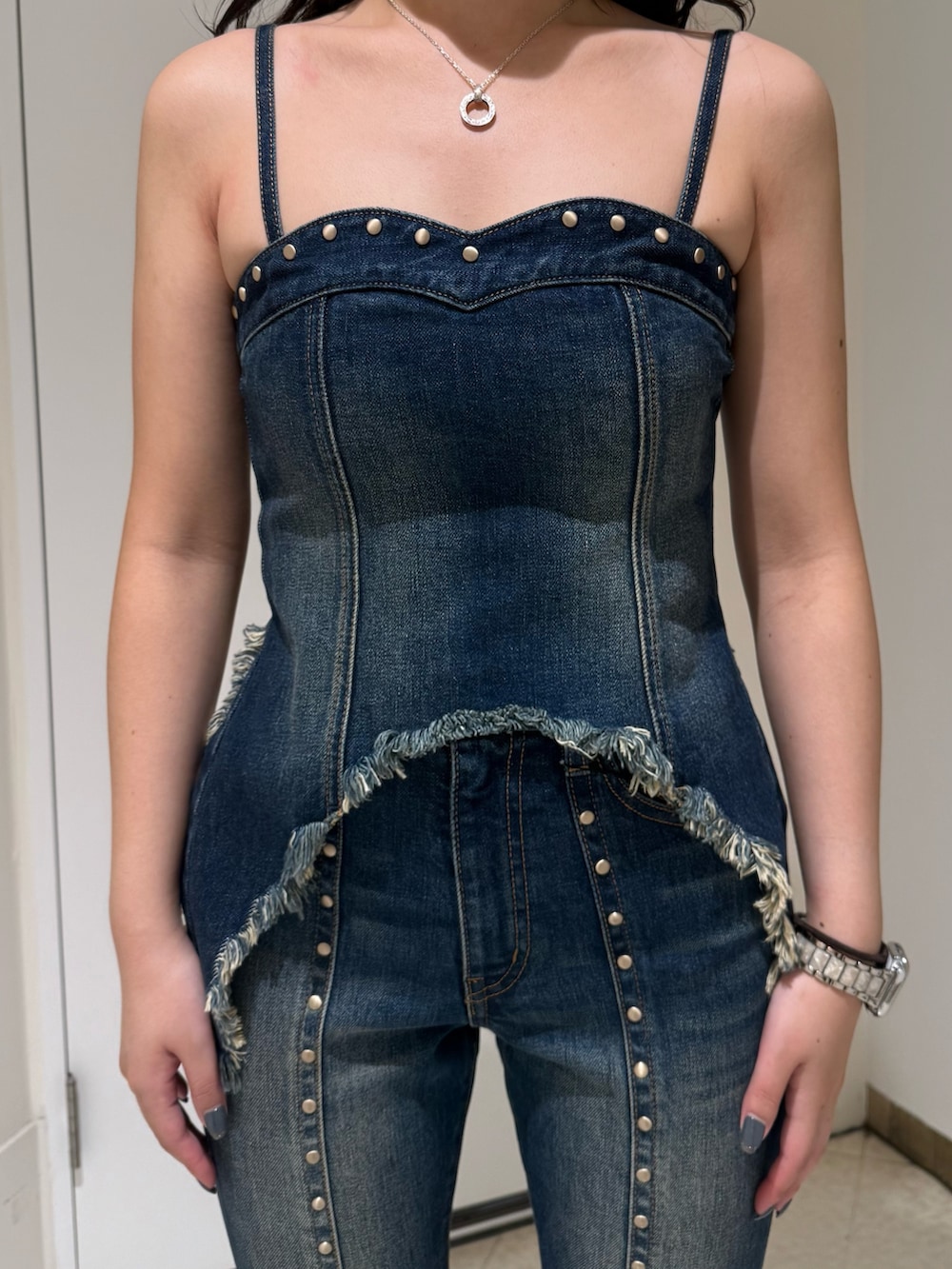 ブルー系のデニムパンツ、ブラック系のブーツ、ブルー系のキャミソールを着用したレディースの夏コーディネートの4枚目の写真