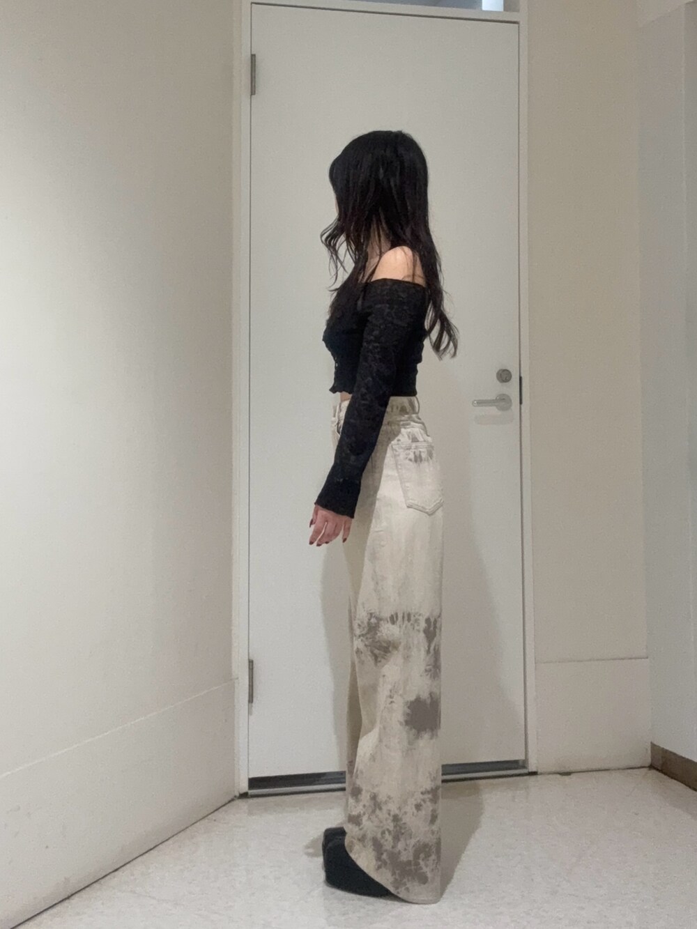 ブラック系のブーツ、ブラック系のTシャツ/カットソー、ベージュ系のデニムパンツを着用したレディースの秋コーディネートの2枚目の写真