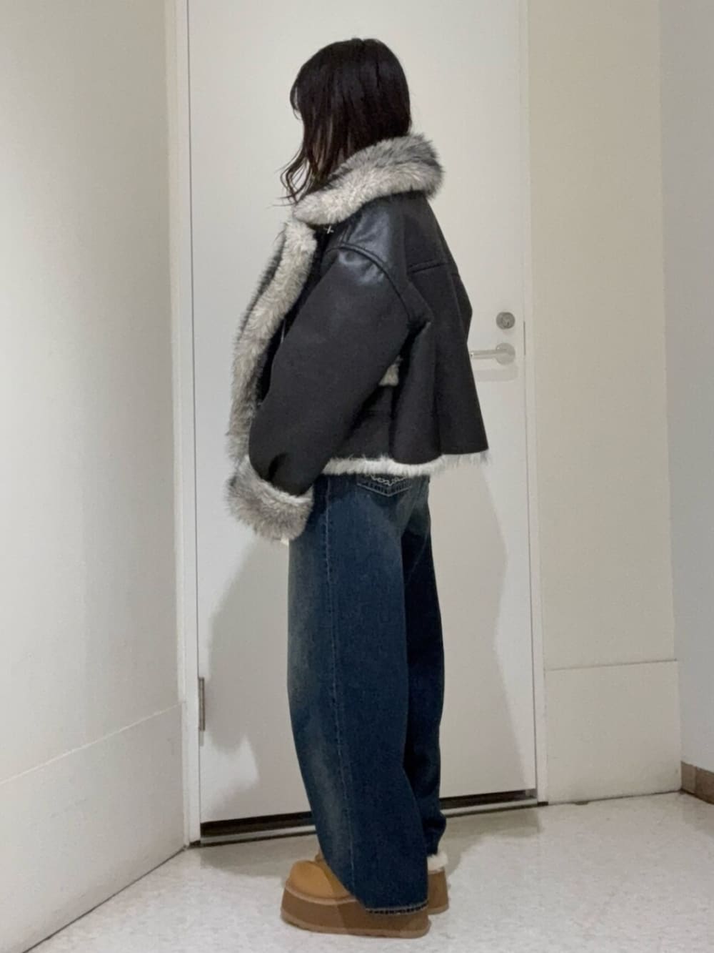 ブラック系のブルゾン、ブルー系のデニムパンツ、ベージュ系のスリッポンを着用したレディースの秋コーディネートの2枚目の写真