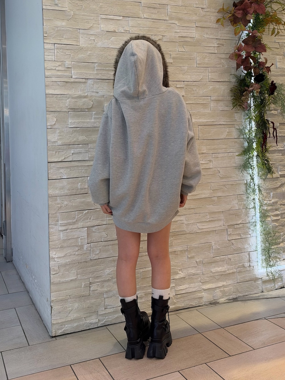 グレー系のパーカー、ブラック系のブーツを着用したレディースの秋コーディネートの3枚目の写真