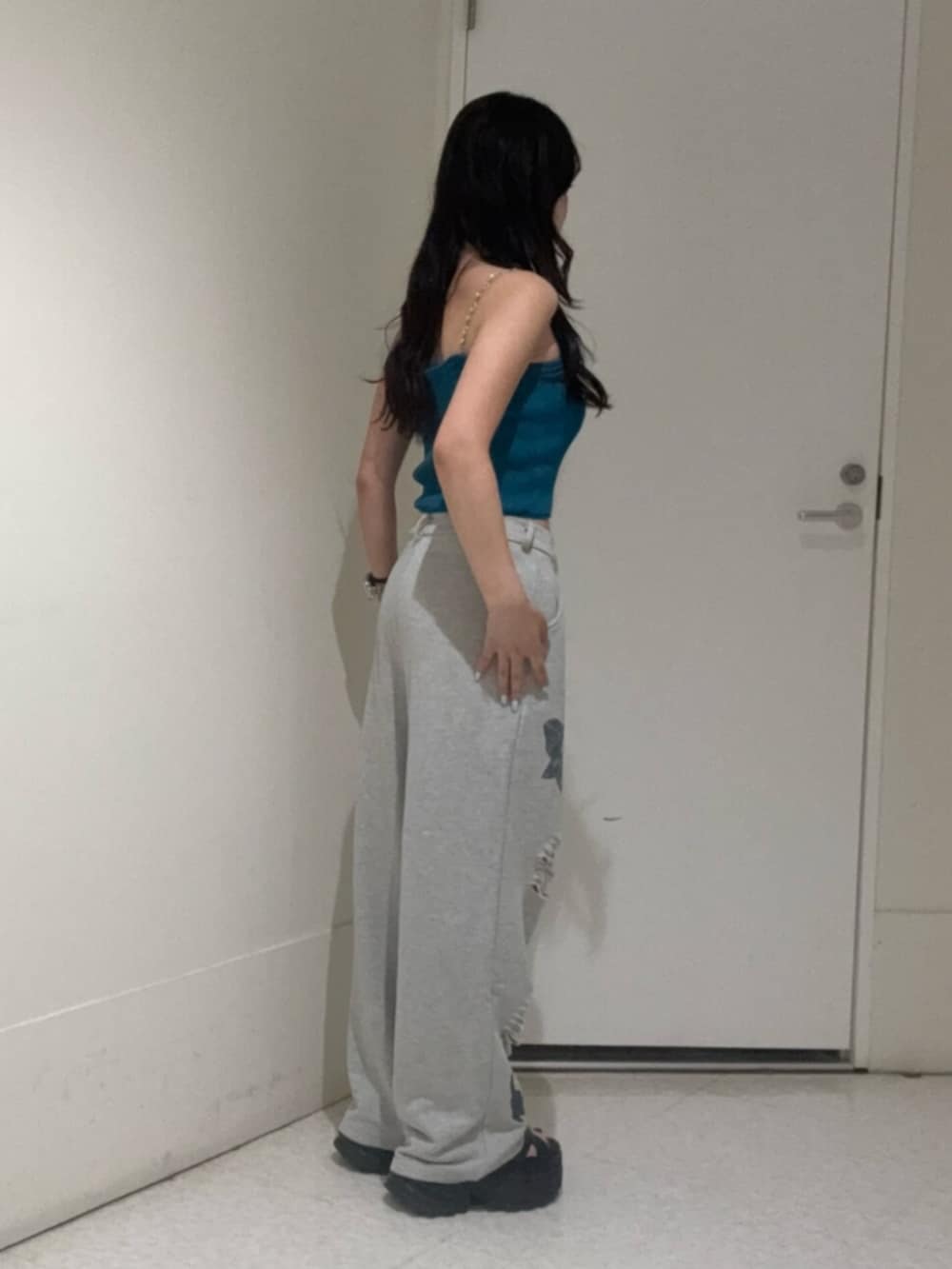 ブラック系のサンダル、ブルー系のキャミソール、グレー系のスウェットパンツを着用したレディースの夏コーディネートの2枚目の写真