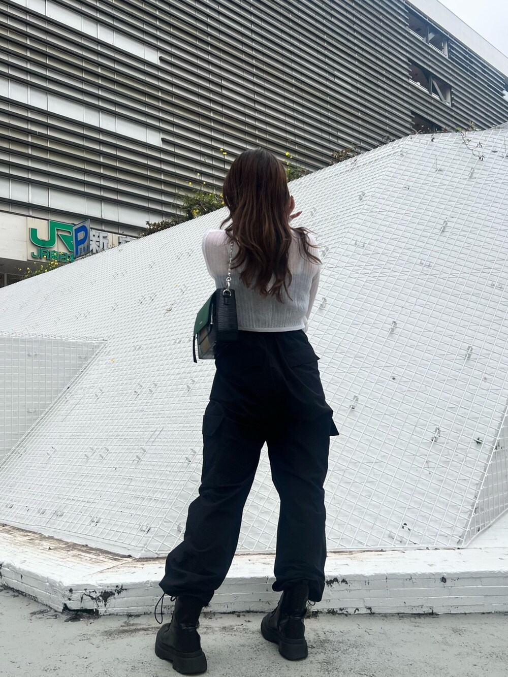 ブラック系のカーゴパンツ、ブラック系のブーツ、ホワイト系のカーディガン/ボレロを着用したレディースの春コーディネートの5枚目の写真