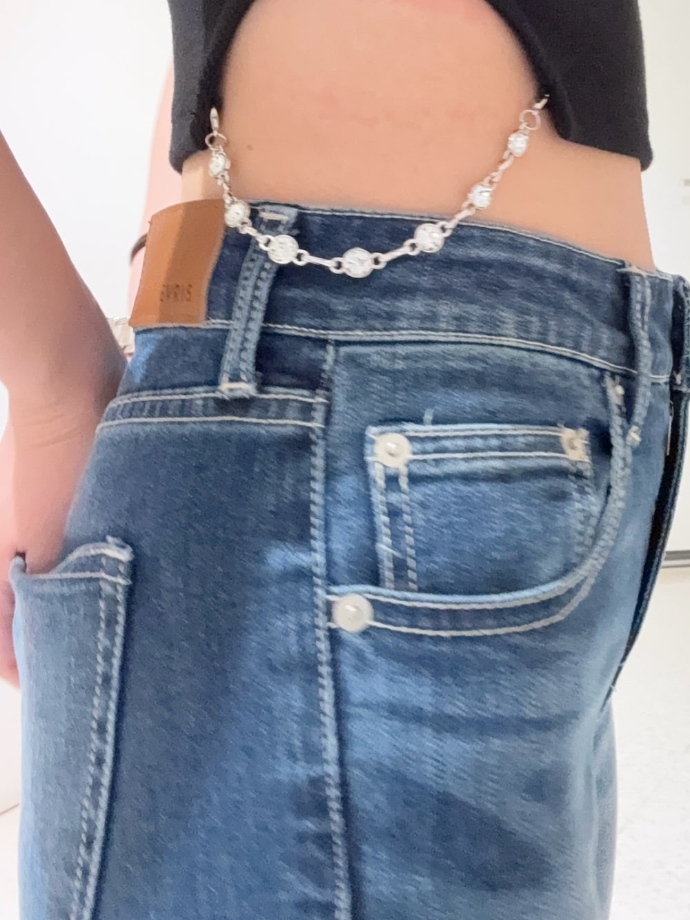 ブラック系のTシャツ/カットソー、ブルー系のデニムパンツ、ブラック系のサンダルを着用したレディースの春コーディネートの5枚目の写真