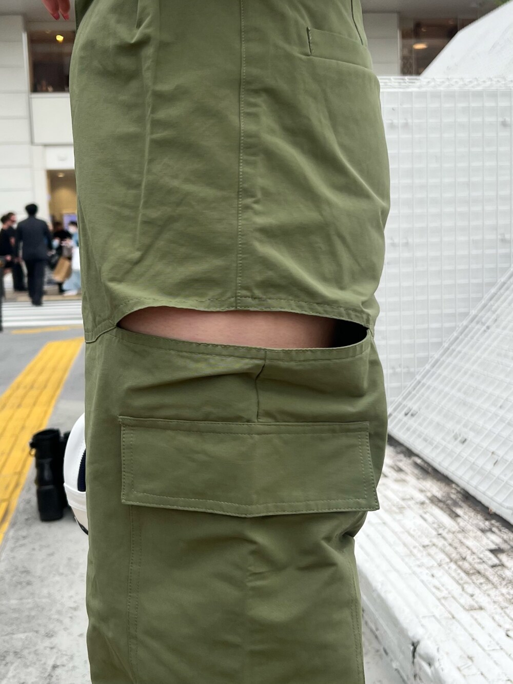 ホワイト系のハンドバッグ、グリーン系のカーゴパンツ、ブラック系のサンダルを着用したレディースの春コーディネートの5枚目の写真