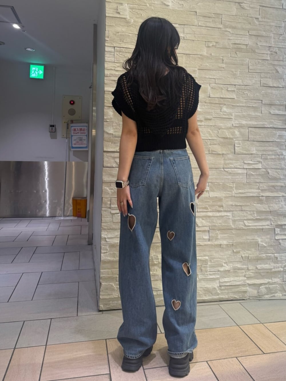 ブラック系のサンダル、ブルー系のデニムパンツ、ブラック系のニット/セーターを着用したレディースの夏コーディネートの3枚目の写真