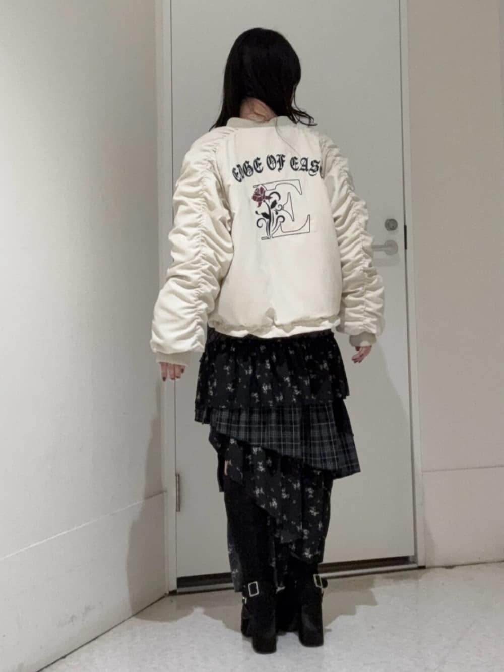 ブラック系のブーツ、ホワイト系のMA-1、その他のスカートを着用したレディースの冬コーディネートの3枚目の写真