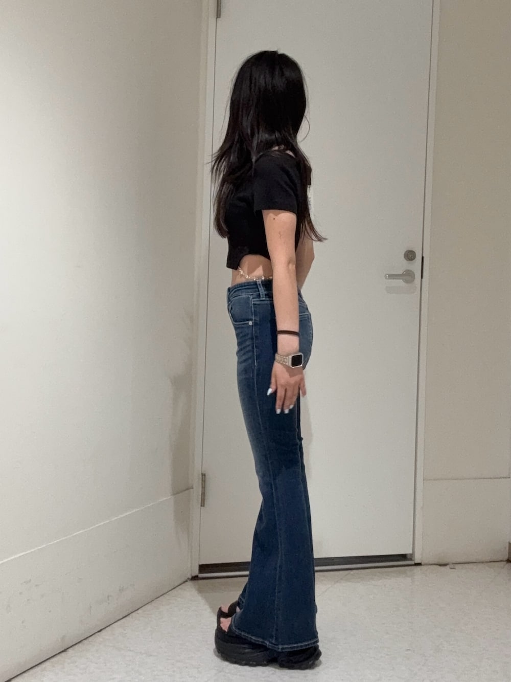 ブラック系のTシャツ/カットソー、ブルー系のデニムパンツ、ブラック系のサンダルを着用したレディースの春コーディネートの2枚目の写真