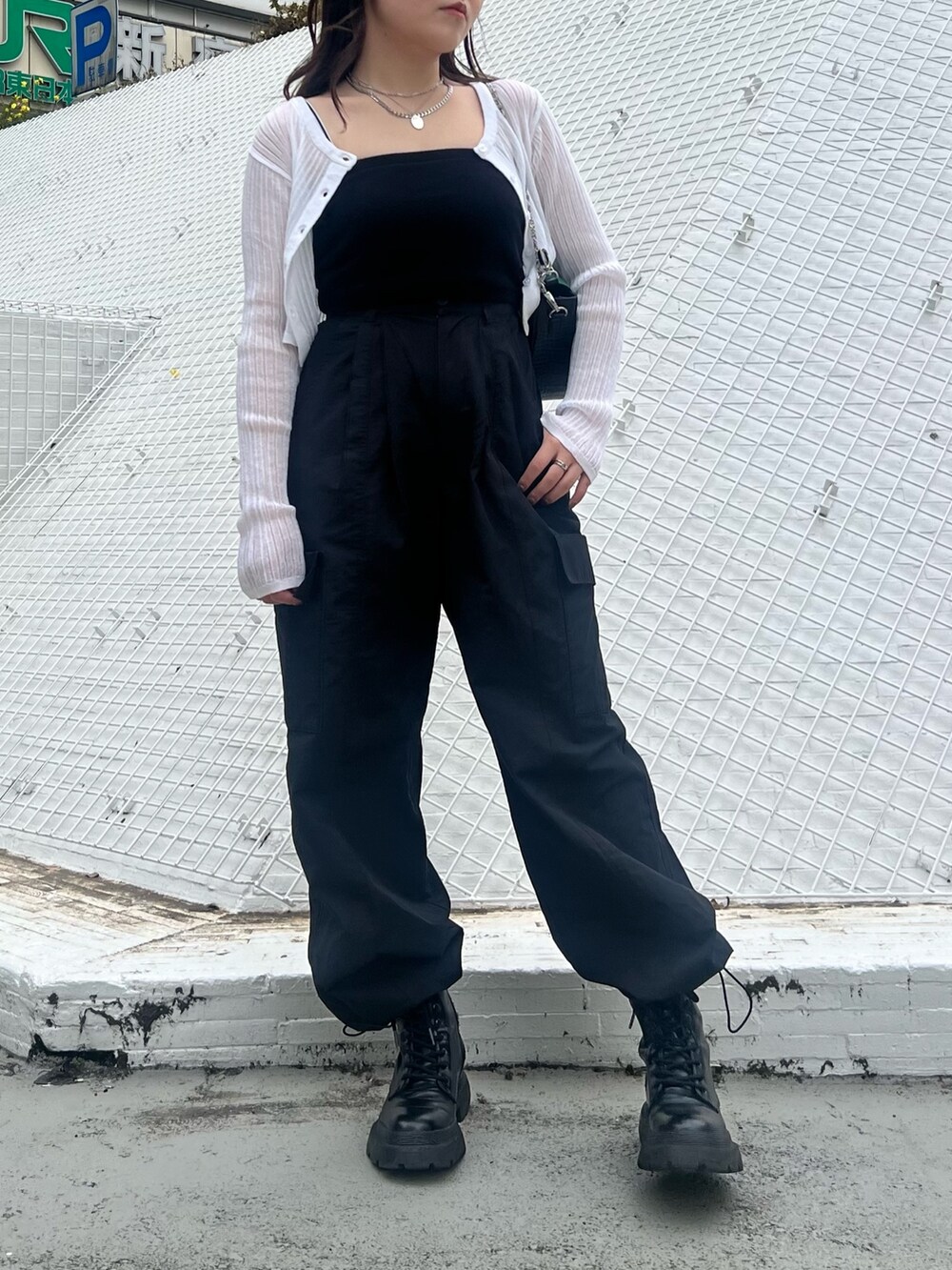 ブラック系のカーゴパンツ、ブラック系のブーツ、ホワイト系のカーディガン/ボレロを着用したレディースの春コーディネートの2枚目の写真