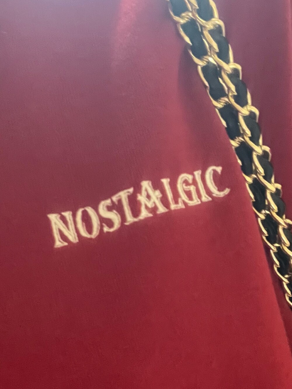 レッド系のスウェット、ブラック系のショルダーバッグ、ブラック系のブーツを着用したレディースの夏コーディネートの7枚目の写真